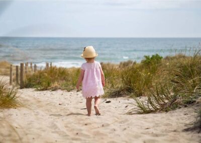 toddler girl on sand dunes walking away