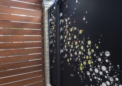 Architectural laser cut gate detail with wooden fence