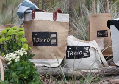 A collection of jute bags, featuring a business logo. Professional product photography in an outdoor beach setting. Content and product photography in Auckland, New Zealand.