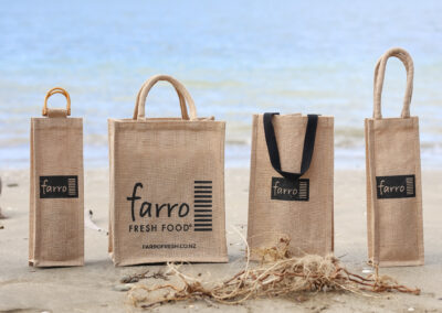 A collection of jute bags, featuring a business logo. Professional product photography in an outdoor beach setting. Content and product photography in Auckland, New Zealand.