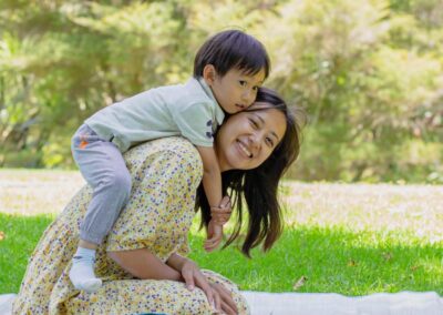 Professional Asian Family portrait with smiling mum and son. Beautiful candid summer family portrait in an Auckland Garden, New Zealand.