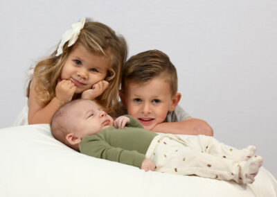 sibling portrait, young girl and boy and newborn brother