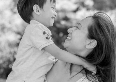 Professional Asian Family portrait with smiling mum and son. Beautiful candid summer family portrait in an Auckland Garden, New Zealand.