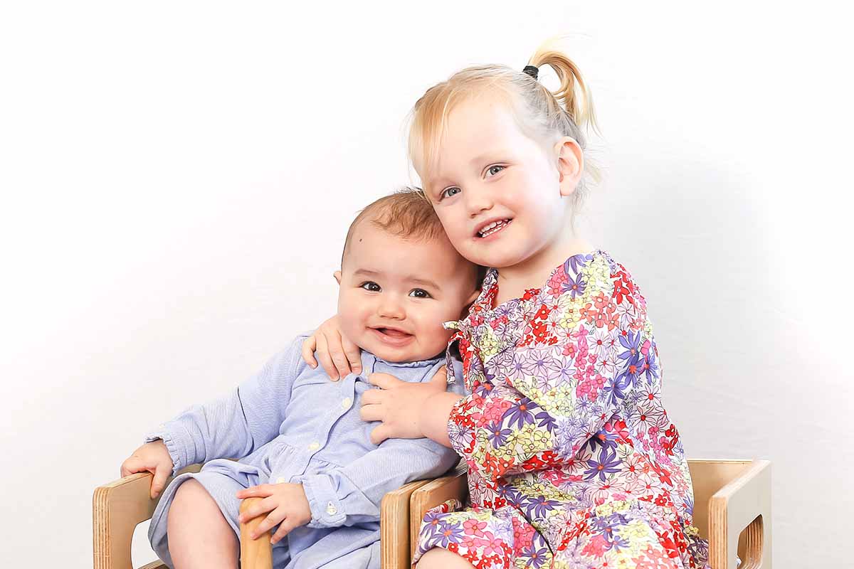 Daycare portrait of cute siblings toddler and baby Auckland, New Zealand.