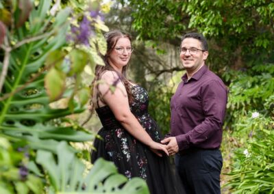 Young couple -looking back behind greenery