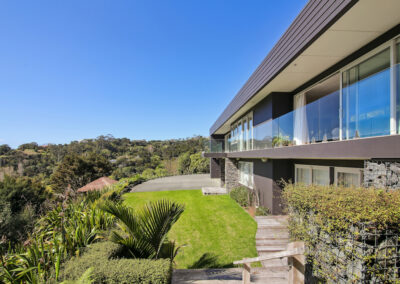 Exterior of High End modern Home with blue skies and green lawn