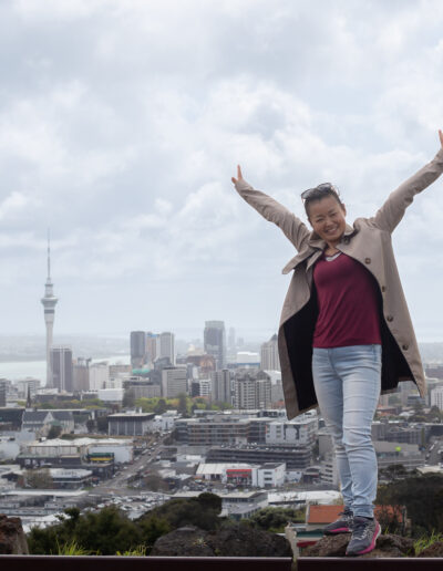 Portrait_happy rasied arm_city scape behind