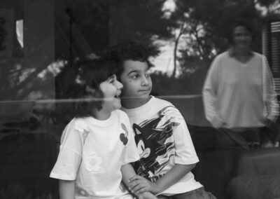 black and white artistic family shot of children in window