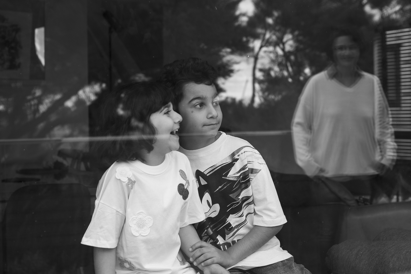 black and white artistic family shot of children in window
