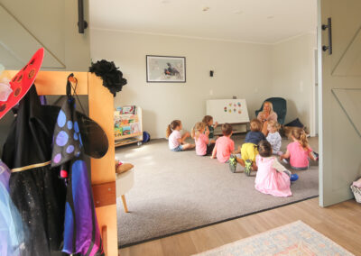 Inside of a daycare, teacher reading to a group of children, light and airy high end photography