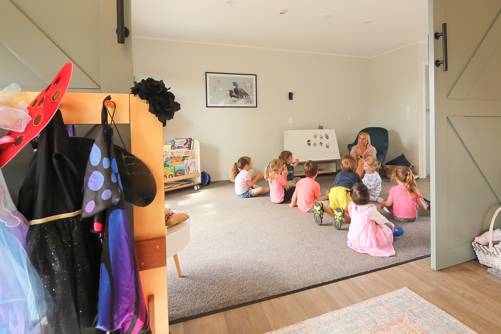 Inside of a daycare, teacher reading to a group of children, light and airy high end photography