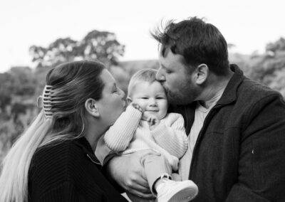 parents kissing baby