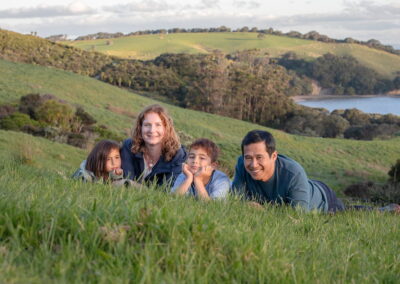 young family lying in grass with beautiful scenery