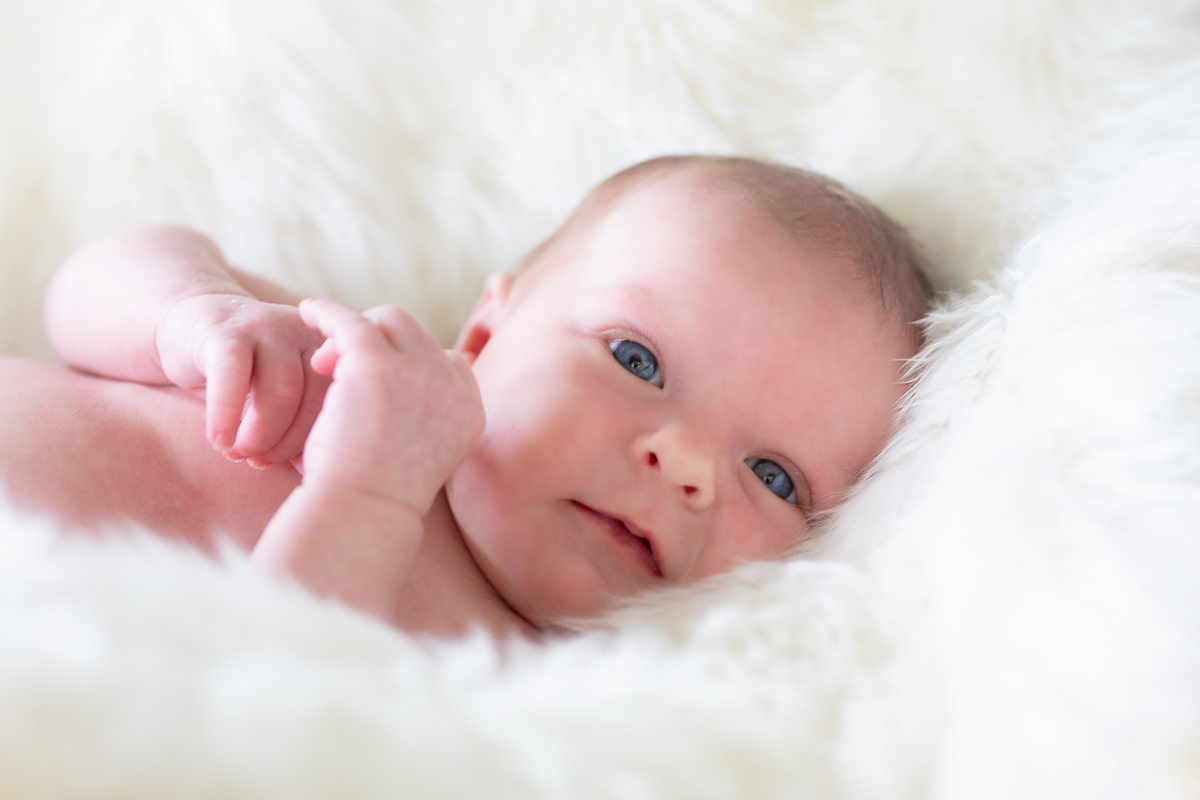 Newborn with a smile and open eyes portrait